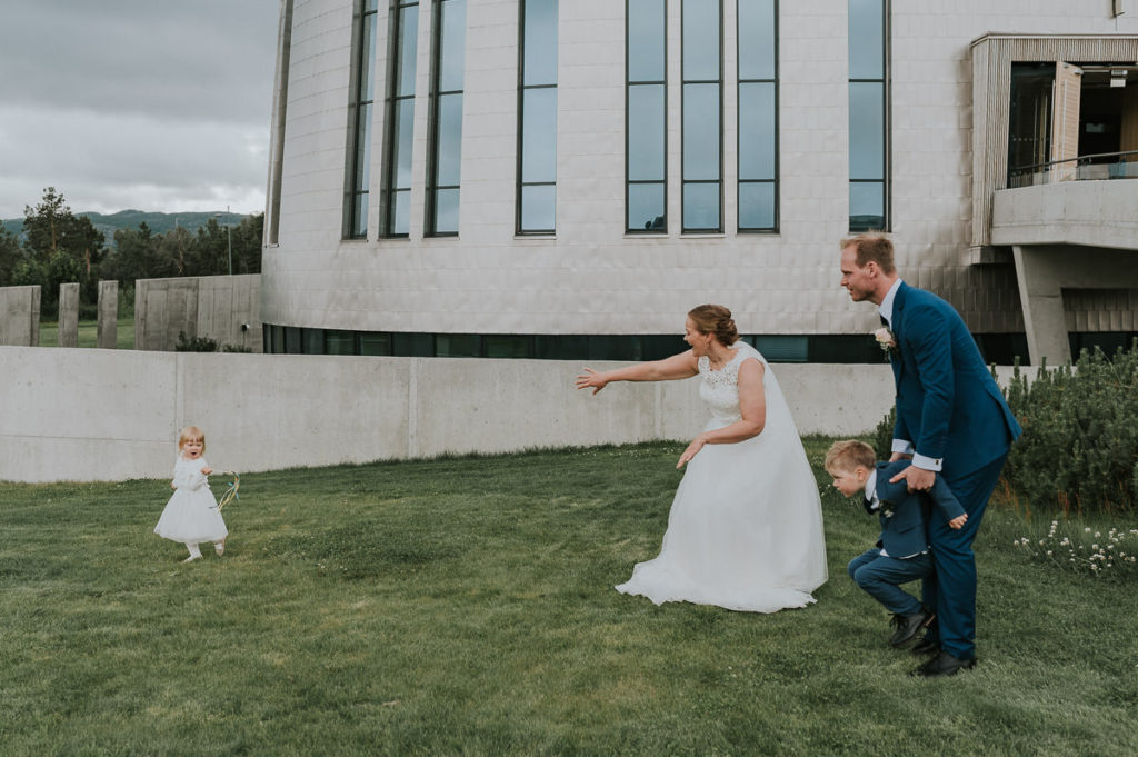Et forsøk på familiefotografering med brudepar og barna utenfor kirka i Alta