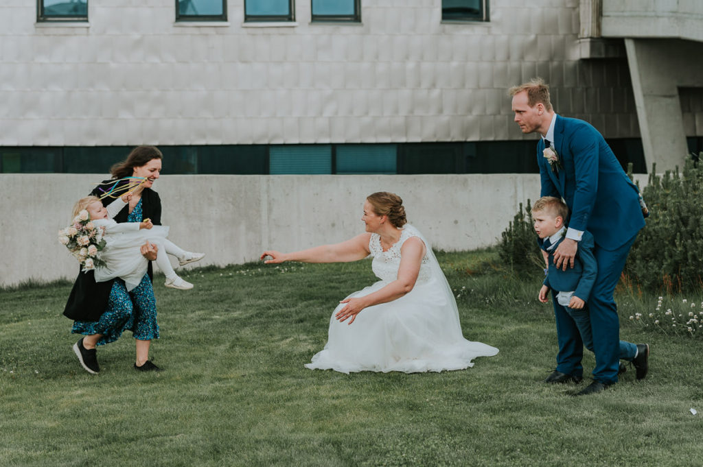 Et forsøk på familiefotografering med brudepar og barna utenfor kirka i Alta