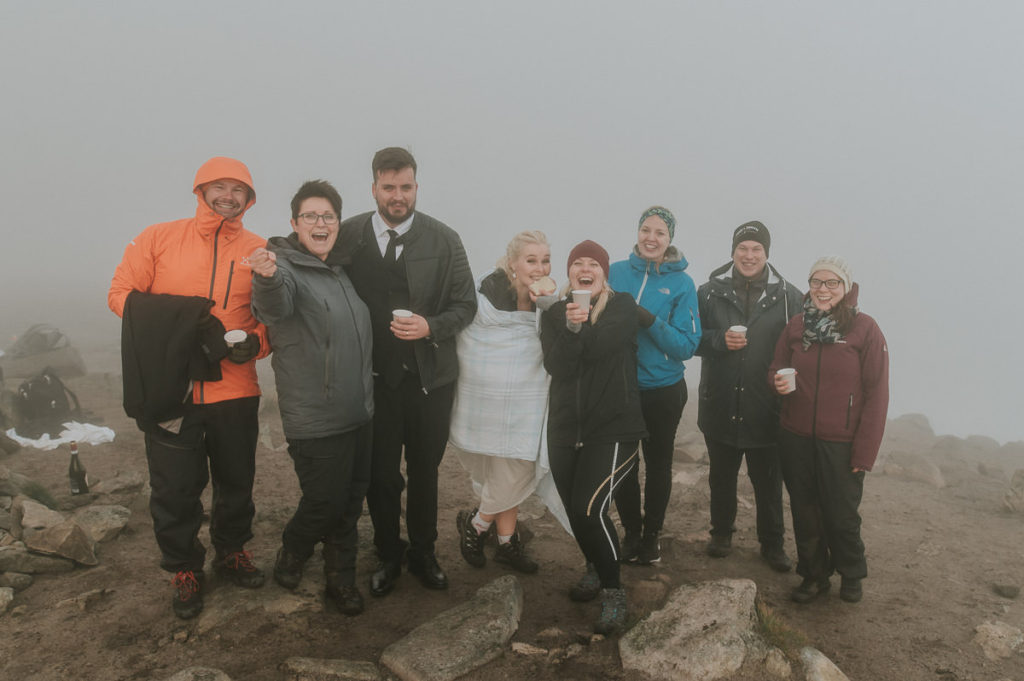 Bride and groom and a small group of their guests are cheering and celebrating an intimate adventure wedding in the mountains of Lofoten islands 