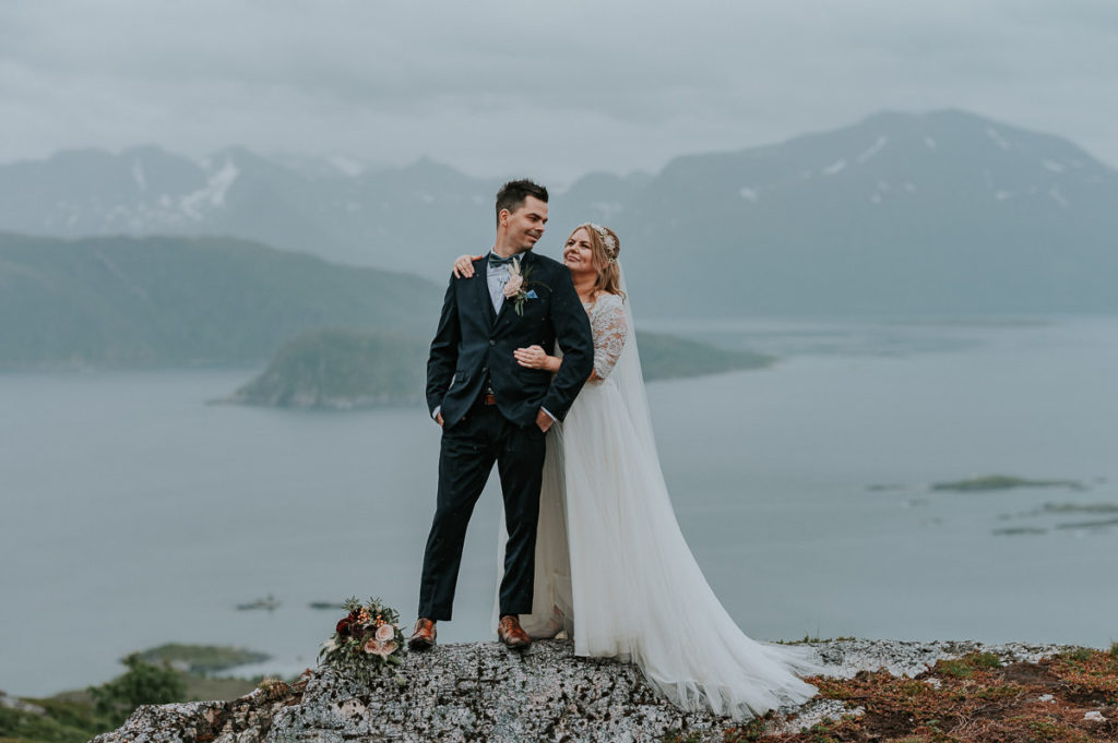 Bride and groom hugging on a mountaintop in  Tromsø on their wedding day