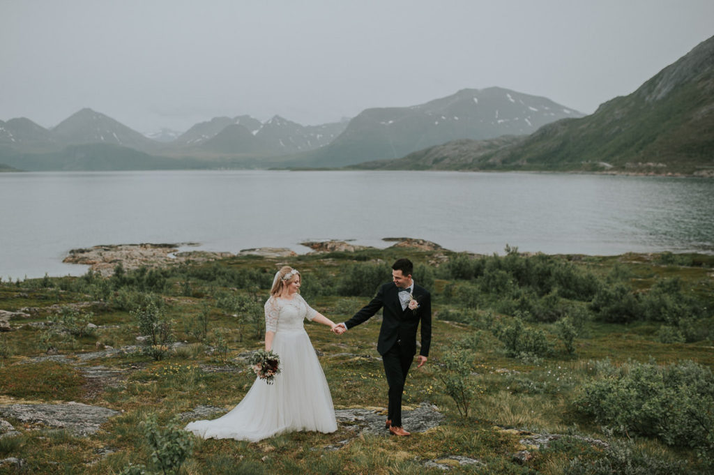 Bride and groom walking near the sea in Sommarøy while holding hands - captured by Tromsø wedding photographer TS Foto Design