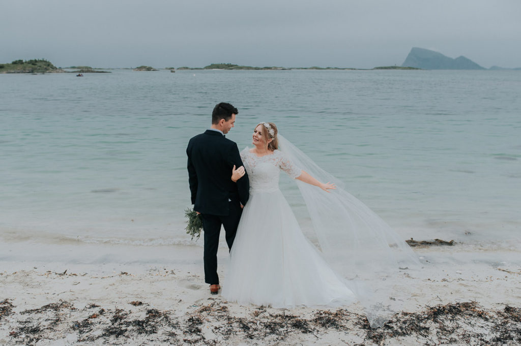 Bride and groom on a beach holding hands and looking into each others eyes - captured by Tromsø wedding photographer TS Foto Design