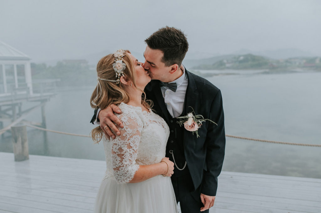 Bride and groom kissing on a rainy day in Sommarøy