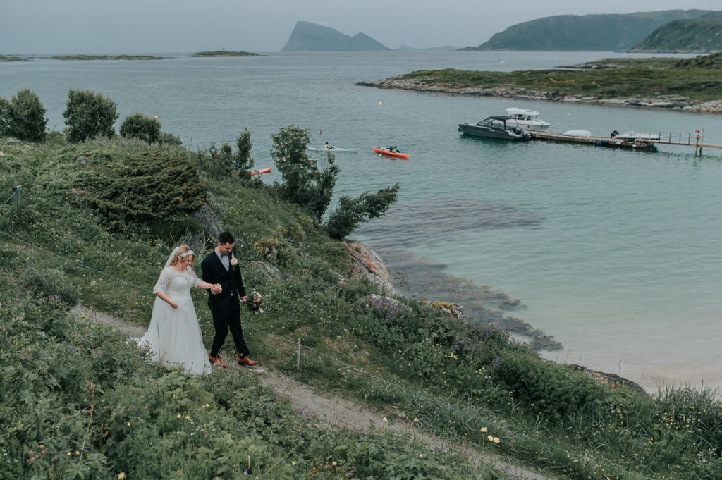 Bride and groom walking towards a beautiful beach in Sommarøy in Tromsø 