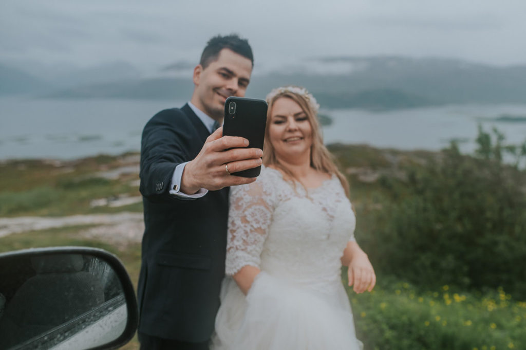 Mountain wedding in Tromsø - bride and groom taking selfie with their phone
