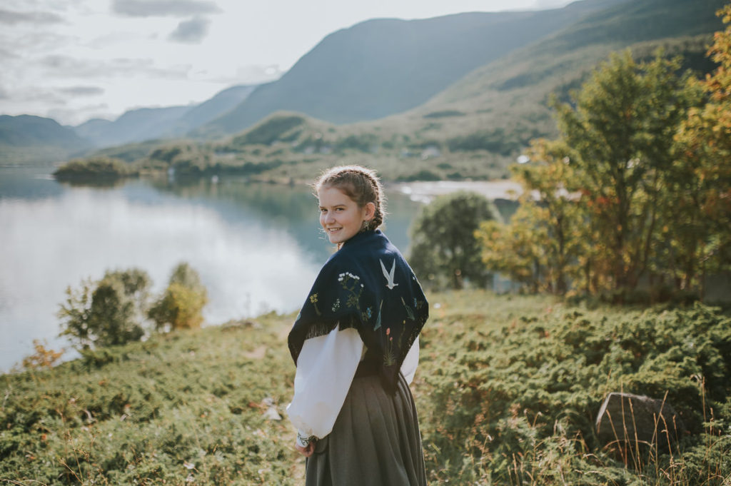 Søt konfirmant jente i en kystdrakt blant nydelige omgivelser i Alta og Kåfjord på konfirmantfotografering 