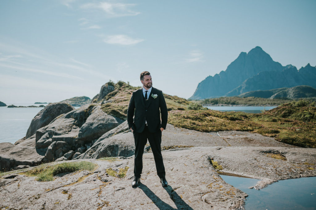 Bride and groom walking near the sea on a sunny summer wedding day in Lofoten 