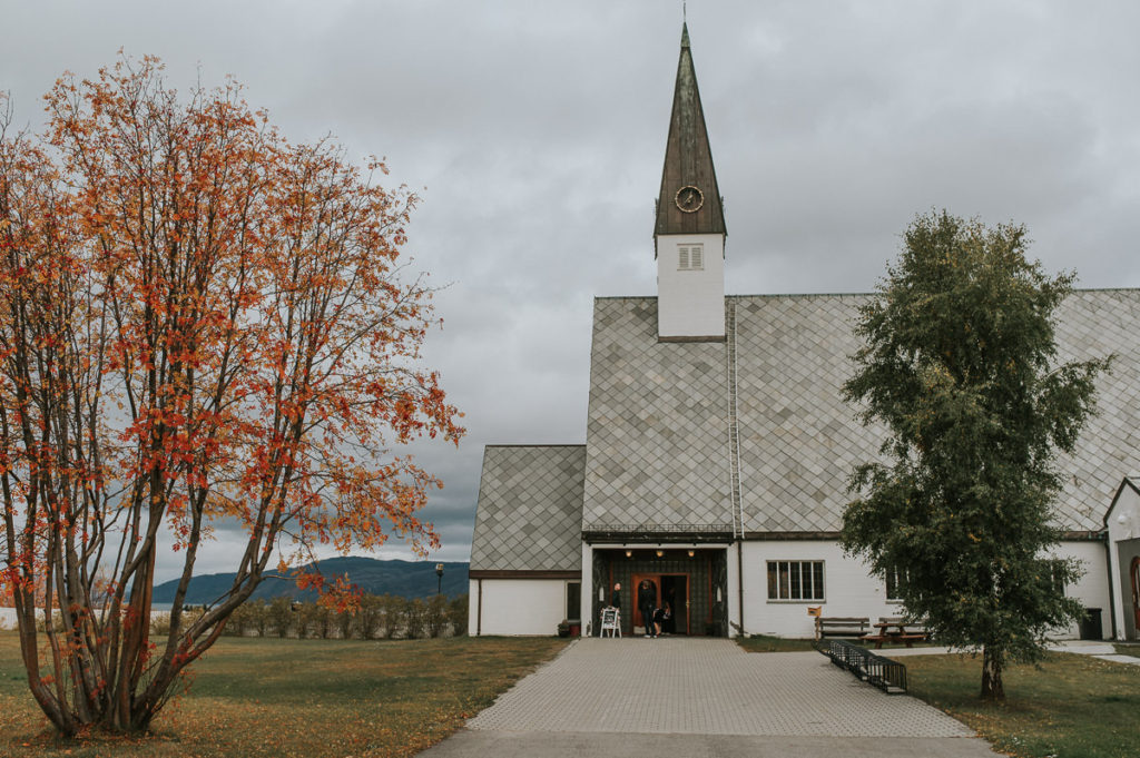 Elvebakken kirke i Alta på en høst bryllupsdag. Trærne ved siden av er farget rødt og gult