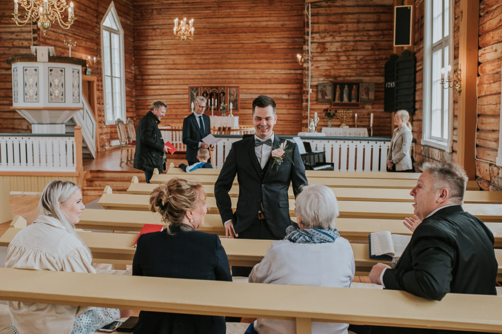 Groom is greeting the guests in Hillesøy church in Tromsø before the wedding ceremony - by Tromsø wedding photographer TS Foto Design