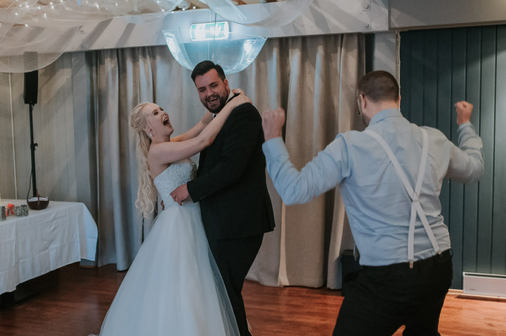 Bride and groom's first dance in a Nyvågar rorbu hotel in Lofoten. Guests are having good time and laughing all the time