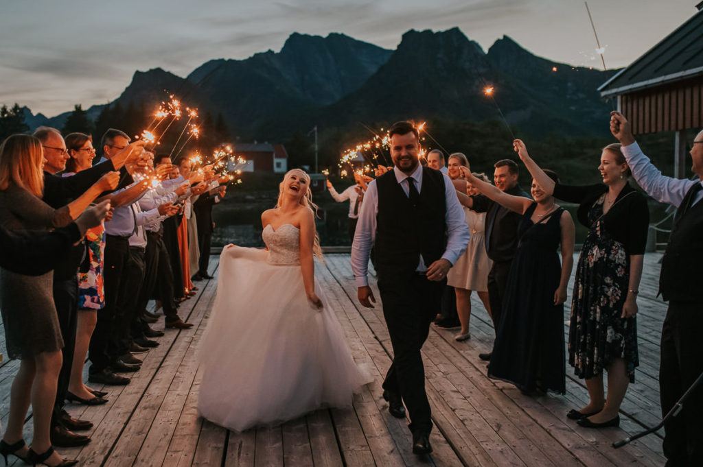 Sparkler exit at the end of the adventure wedding day in Lofoten Norway. Bride and groom are dancing trherugh the exit and laughing