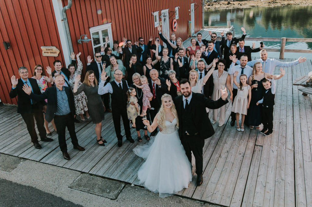 Group wedding portrait with the bridal couple, family and friends - summer wedding in Lofoten
