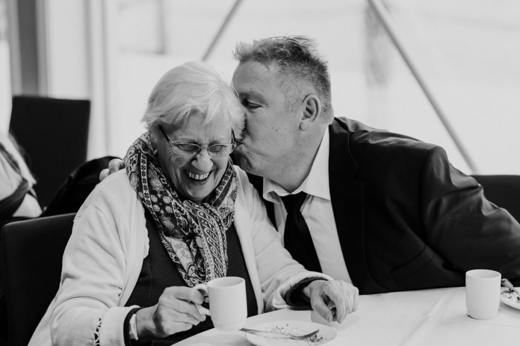 Nice moments from a wedding party in Tromsø - a man is kissing bride's grandma on the cheek and she is laughing
