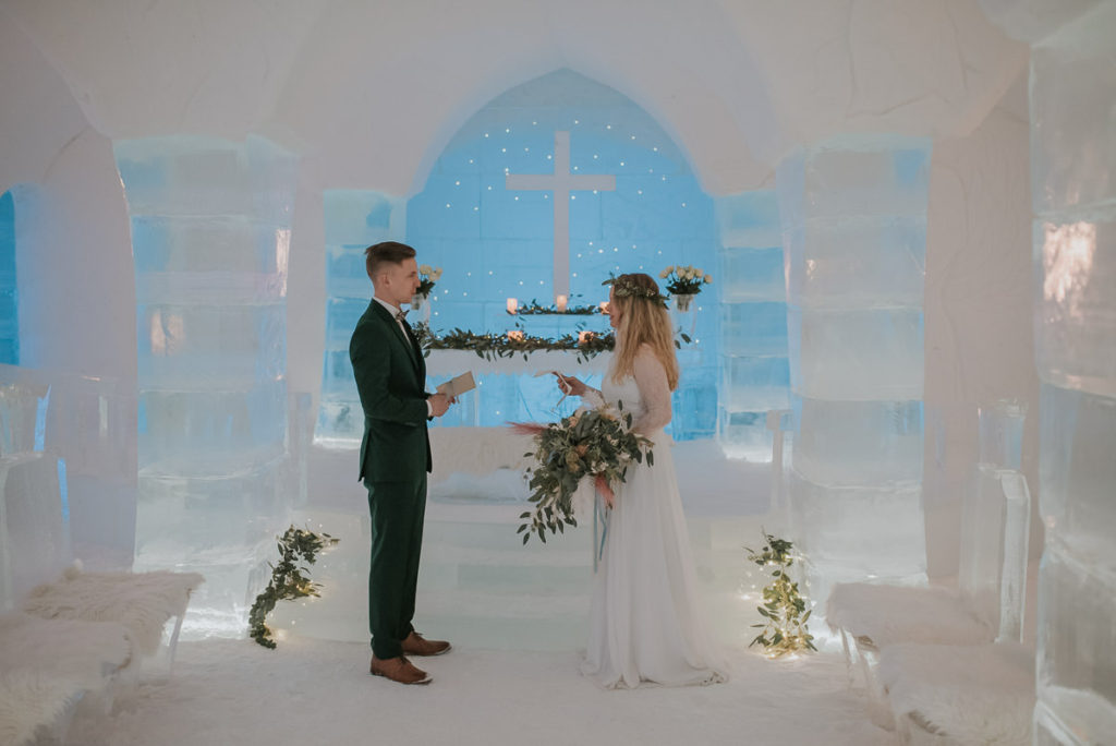 Bride and groom reading their vows to each other in the ice chapel of ice hotel in Alta Norway 