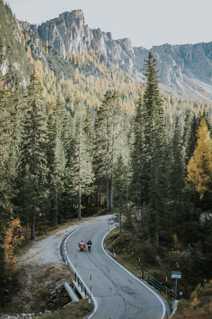 Bride and groom running in the middle of the road in Northern Italy - captured by Dolomites elopement photographer
