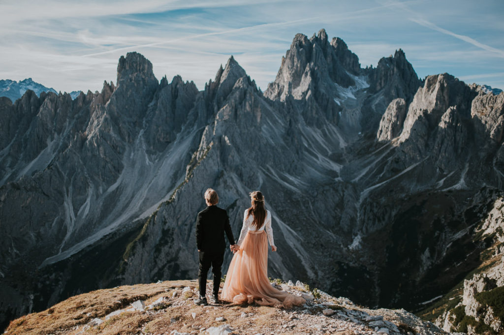 Bride and groom portrait facing the stunning rugged Italian Dolomites - captured by Dolomites elopement photographer TS Foto Design