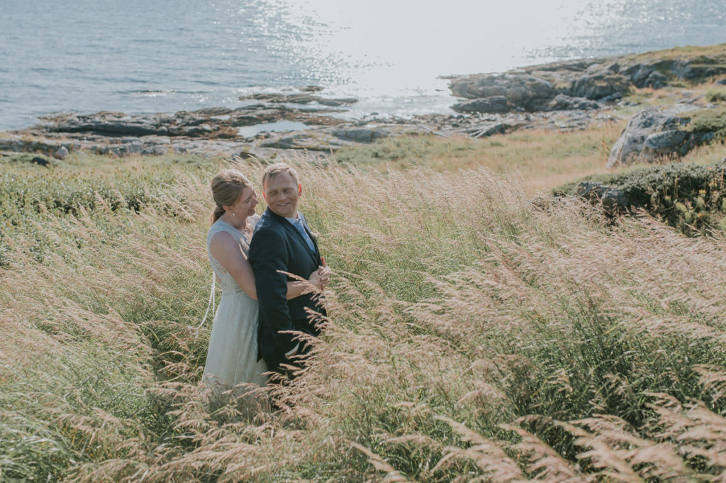 Elopement in Norway by the fjords and mountains - bride and groom in a grass field - captured by elopement photographer TS Foto Design
