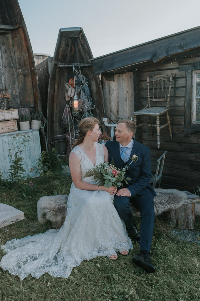Bridal portraits in front of rustic wall with wooden decorations outdoors