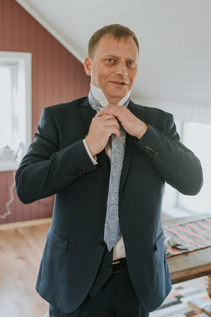 Groom getting ready at a cabin in Storekorsnes Alta Norway 