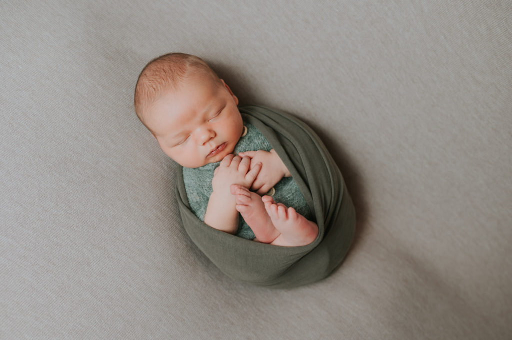 Nyfødt gutt i en grønn wrap