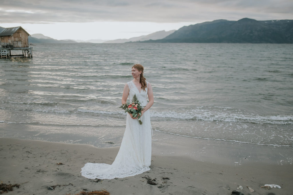 Beautiful bride in a lace bohemian dress on a beach in Norway
