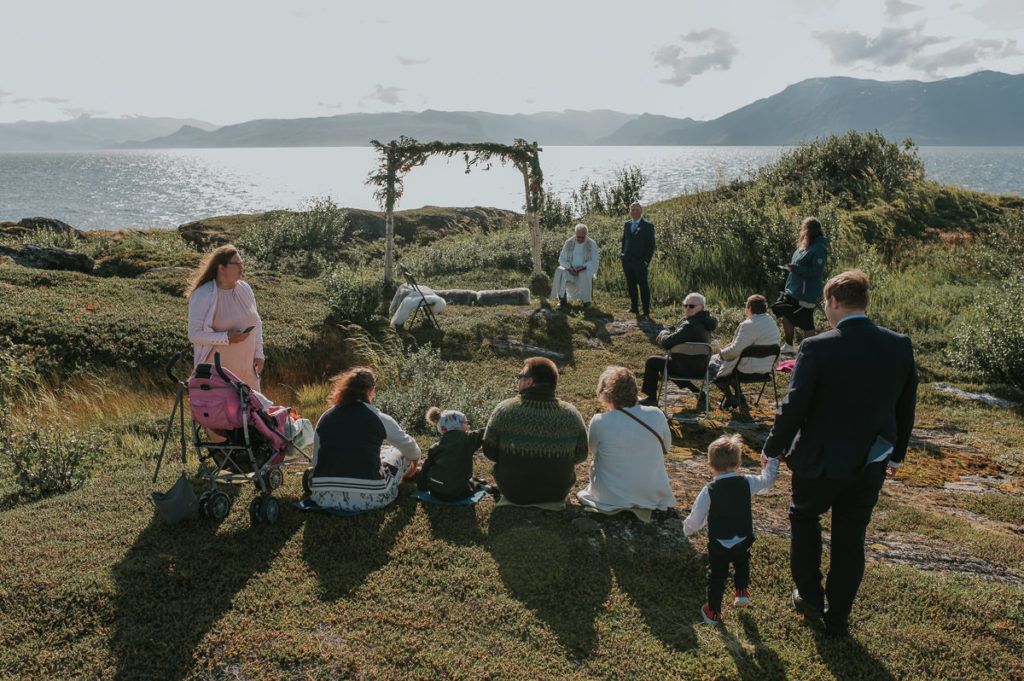 Intimate outdoor wedding ceremony in Alta Norway by the fjords with a sea view and mountains