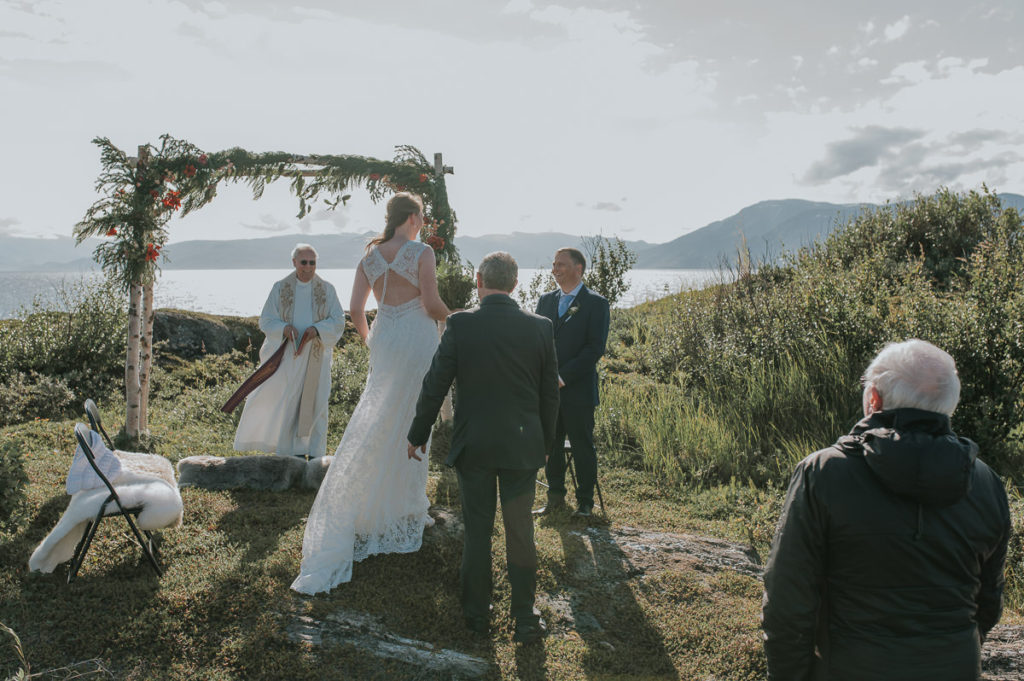 Intimate outdoor wedding ceremony in Alta Norway by the fjords with a sea view and mountains