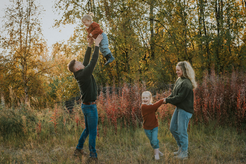 Familiefotografering i Alta  på en høstdag - foreldre leker med sine to små døtre