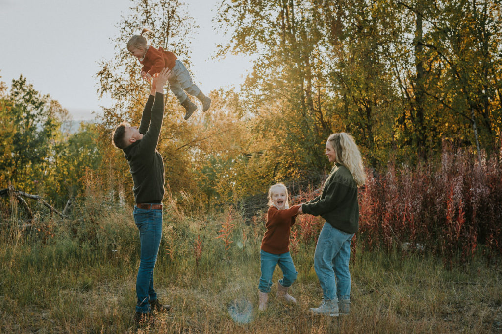 Familiefotografering i Alta  på en høstdag - foreldre leker med sine to små døtre med nydelige høstfarger og solnedgang i bakgrunn