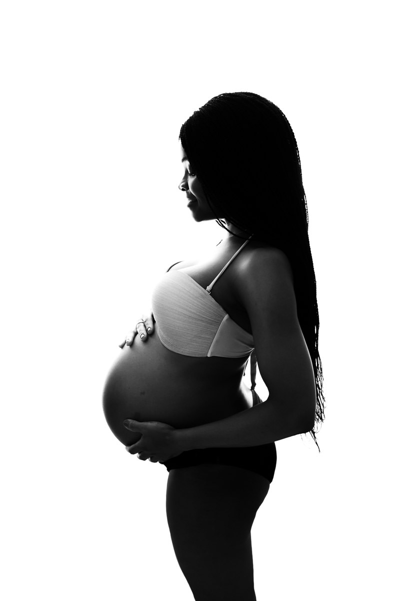 Gravid mamma vordende mor holder magen sin på gravidfotografering i studio i Alta