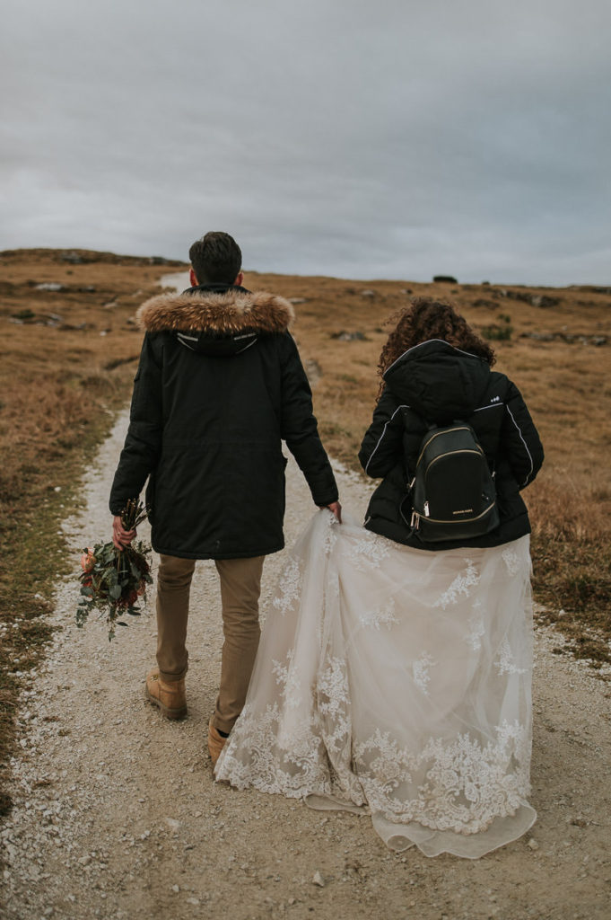 Bride and groom walking in the mountains on the day of their elopement 
