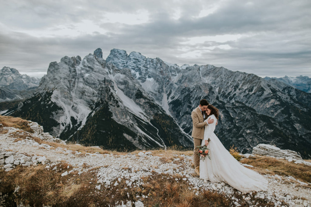 Bride and groom hugging among  the Italian Dolomites mountains  on the day of their adventure elopement 
