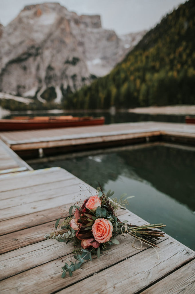 Wedding bouquet on a bay near a beautiful italian lake surrounded by amazing limestone mountains