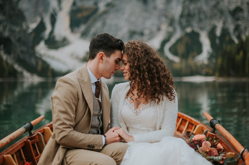 Beautiful bride and groom portrait in a boat on Italian mountain lake