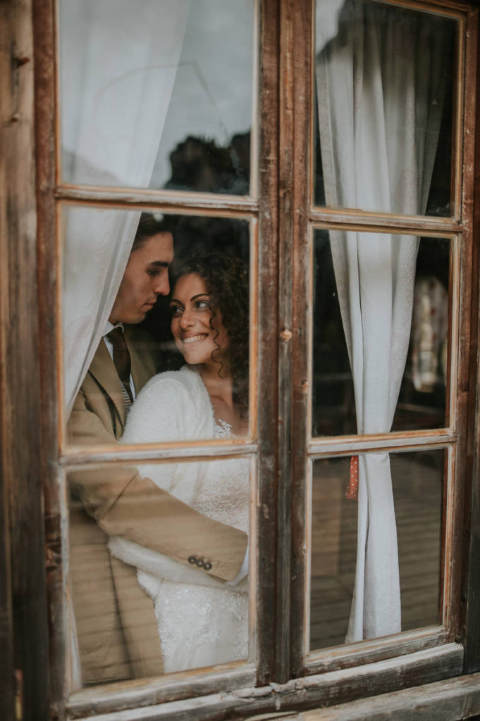 Portrait of a bride and groom looking at each other in a wooden boat house in Northern Italy