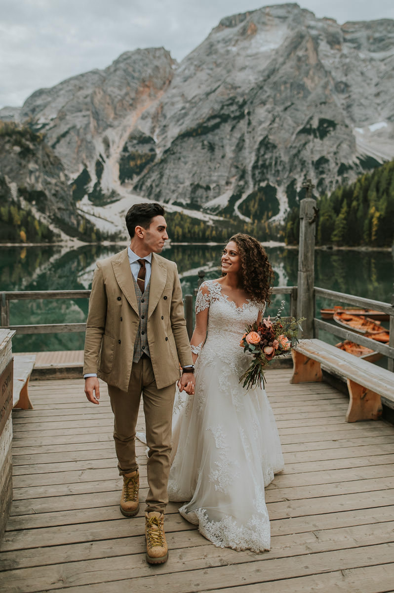 Bride and groom walking on a quay at Lake Braies Pragser wildsee on their wedding day