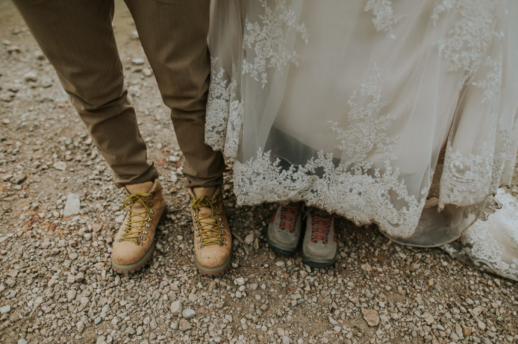 Bride and groom showing their dirty boots after hiking on their elopement day in Italy
