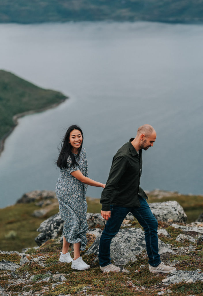 Engagement photo session in the mountains of Tromsø - couple hugging each other and smiling among beautiful scenery