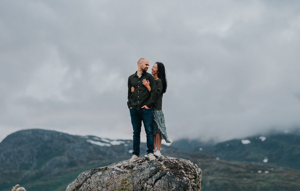 Beautiful couple hugging each other and smiling outdoors enjoying mountain views