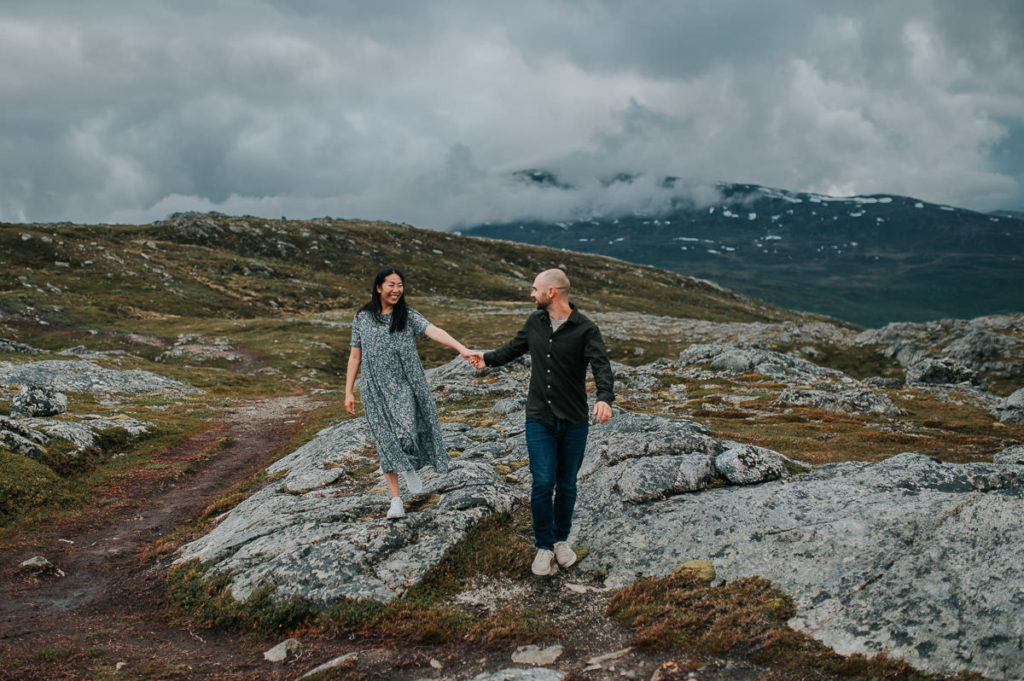 A couple hiking in the mountains and holding hands - engagement pre-wedding photo session phtoshoot in Tromsø by elopement photographer TS Foto Design