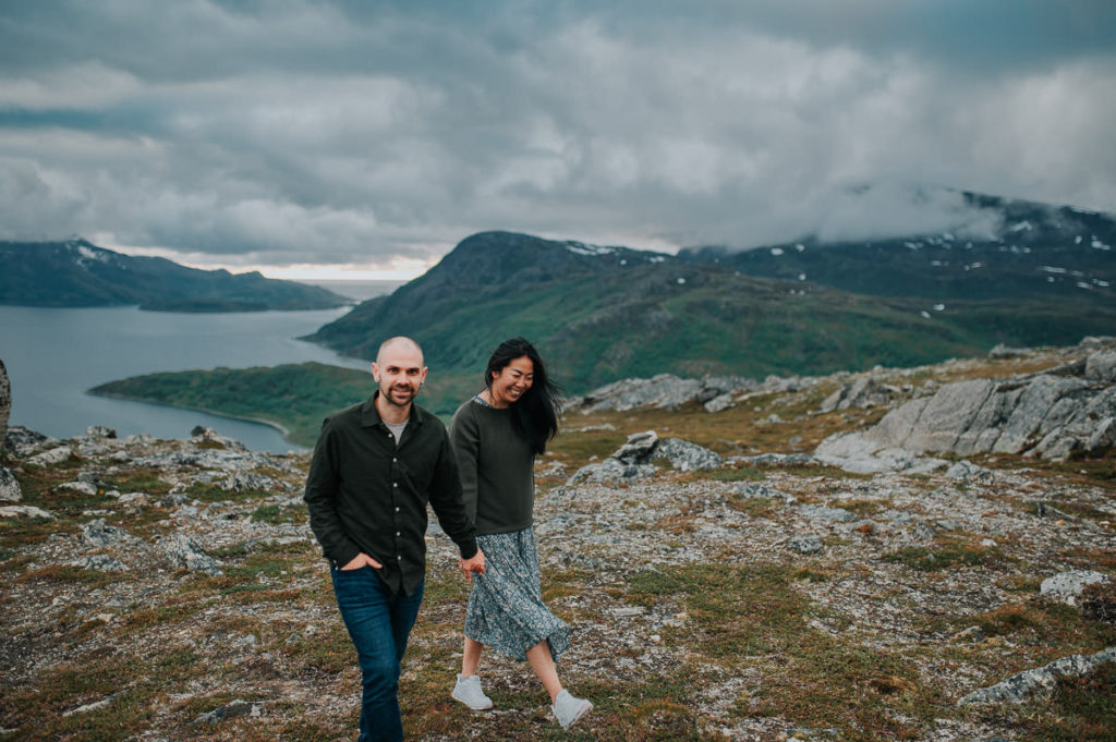 A couple hiking in the mountains and holding hands - engagement pre-wedding photo session phtoshoot in Tromsø by elopement photographer TS Foto Design