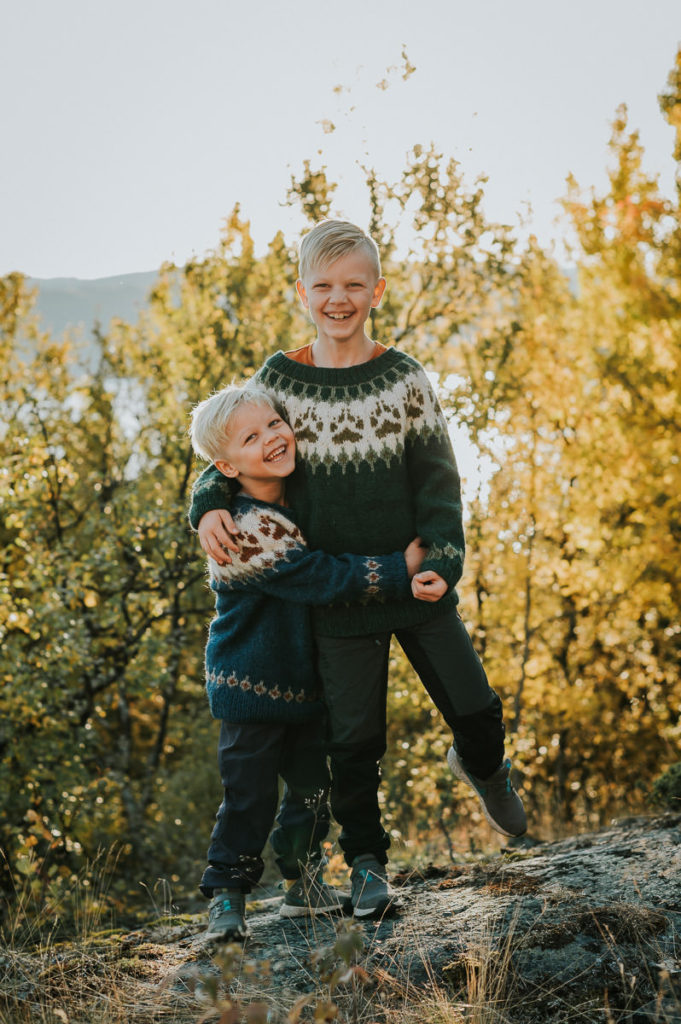 To brødre klemmer hverandre og flirer ute i naturen på en nydelig høstdag i Alta Finnmark