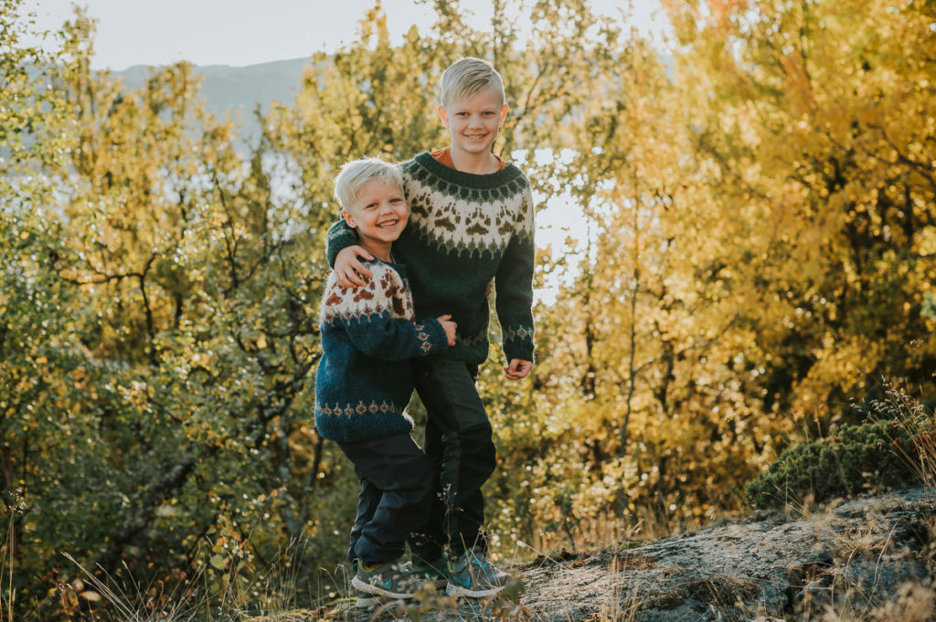 To brødre klemmer hverandre og flirer ute i naturen på en nydelig høstdag i Alta Finnmark