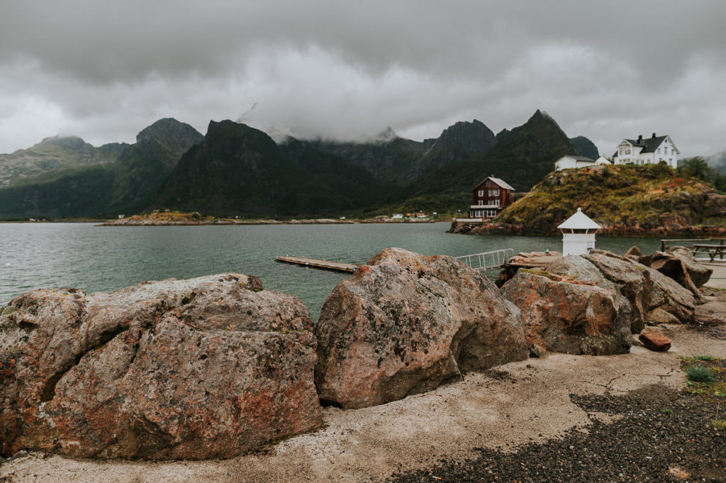 a landscape of Lofoten in Norway with old houses and mountains and the sea