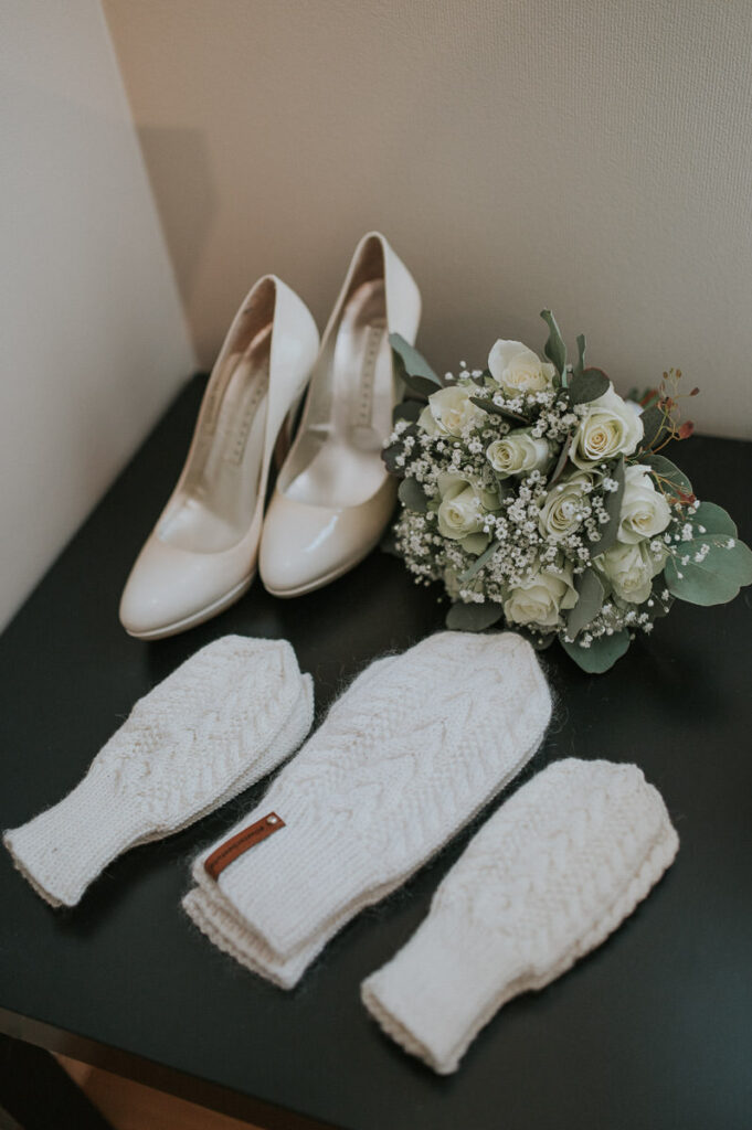 Bridal accessories for a winter wedding in Norway: warm white gloves, shoes and the bouquet