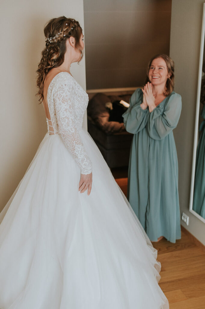 Beautiful bride getting ready for her winter wedding ceremony in Alta Norway  - maid of honor is thrilled seing the bride for the first time