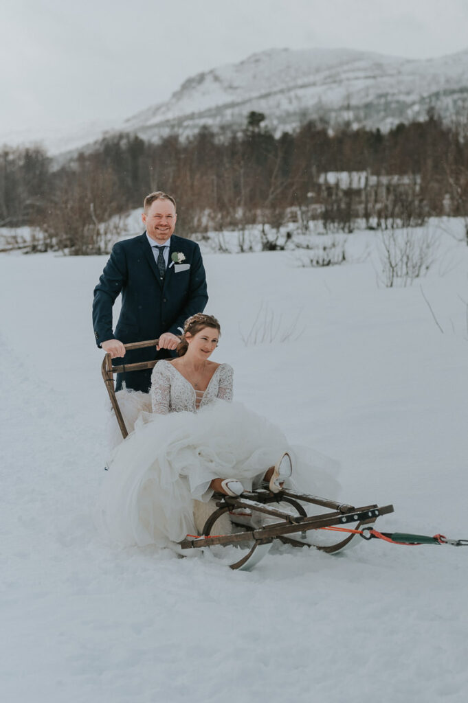 Bride and groom dogsledding to their winter wedding in Sorrisniva Alta Norway