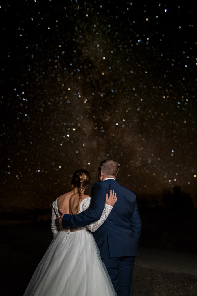 Bride and groom portraits under the stars and milky way - stargazing wedding elopement photos in Alta Norway