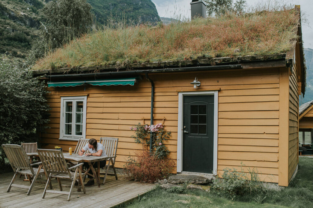 Groom sitting outside of an airbnb in Loen Western Norway and writing his wedding vow 