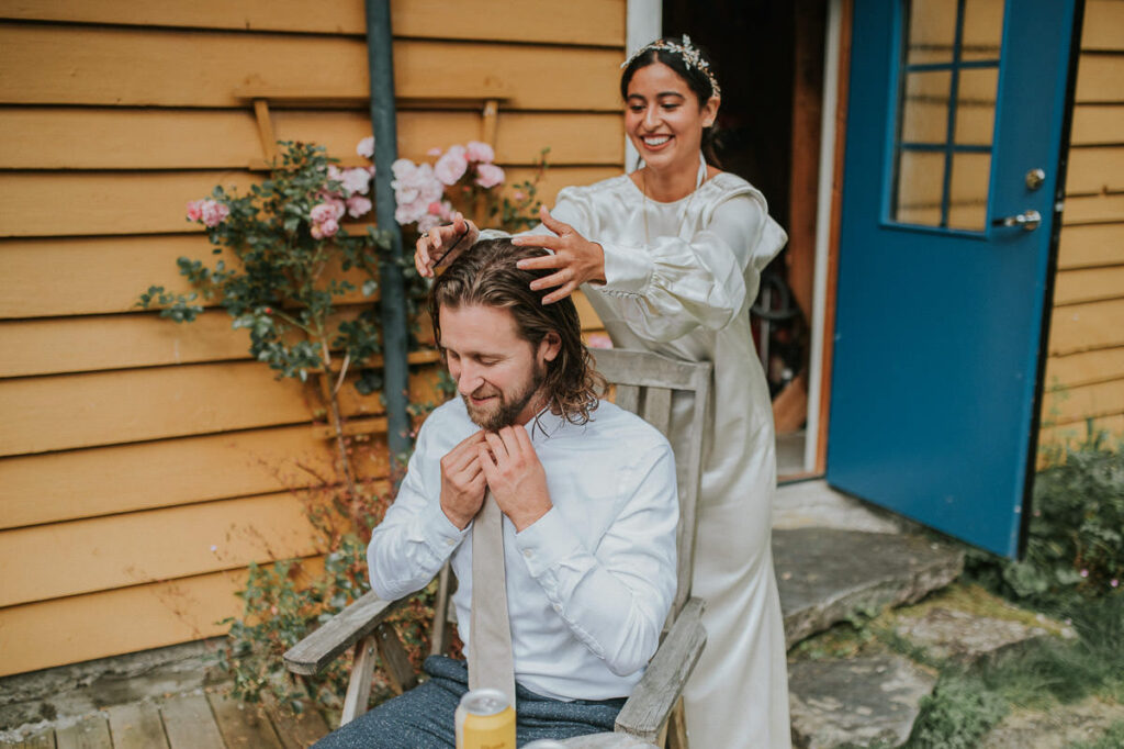 Bride is helping groom with his hair before their wedding ceremony